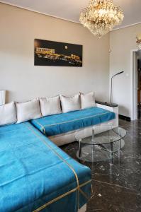 a living room with two blue beds and a chandelier at Piraeus yacht view apartment in Piraeus