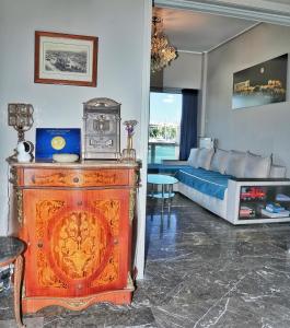 a living room with a bed and a wooden dresser at Piraeus yacht view apartment in Piraeus