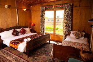 um quarto com 2 camas e uma janela em Golden Flower Heritage Houseboat em Srinagar