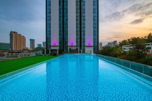 a large swimming pool in front of a tall building at Kyushu Joycheng Hotel in Shenzhen