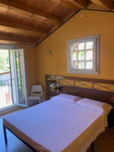 una camera con letto e finestra di Le Casette di Olga -Space for Nature and Sport Lovers- a Baone