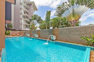 uma piscina num hotel com palmeiras ao fundo em Chic studio Emerald em Praia de Kata