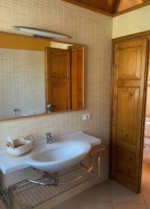 bagno con lavandino bianco e specchio di Le Casette di Olga -Space for Nature and Sport Lovers- a Baone