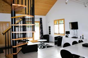 Habitación con mesa, sillas y escalera de caracol. en chalet de charme le contemporain, en Ney