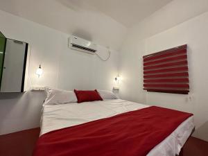 1 dormitorio con 1 cama con manta roja en Coastal Cabana Marari, en Mararikulam