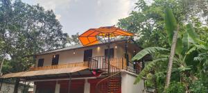 - un parasol orange au-dessus d'une maison dans l'établissement Coastal Cabana Marari, à Mararikulam