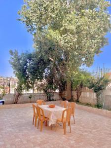 a table and chairs with a tree in a courtyard at Great location apartment in Amman