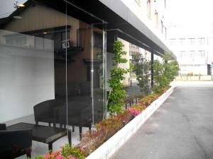 un edificio con plantas a su lado en Green Rich Hotel Tosu Ekimae, en Tosu