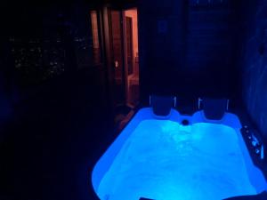 ein dunkles Bad mit einer Badewanne mit Stühlen in der Unterkunft Ferienwohnung mit wunderschöne Aussicht, Whirlpool und Sauna in Gordola
