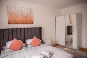 - une chambre avec un lit doté d'oreillers orange et d'un miroir dans l'établissement Prostorný byt v centru u řeky, 2 ložnice, balkón, à Hradec Králové