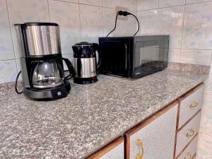 eine Küchentheke mit einer Mikrowelle und einer Kaffeemaschine in der Unterkunft Great location apartment in Amman