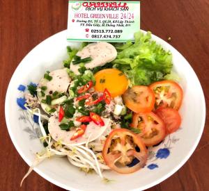 a white plate of food with noodles and tomatoes at Green Ville Hotel Đồng Nai in Xa Dau Giay