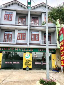 una tienda frente a un edificio con ventanas rojas en Green Ville Hotel Đồng Nai en Xa Dau Giay