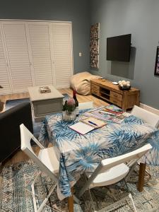 sala de estar con mesa, sillas y TV en 2-Bedroom apartment - Riverside bliss in Paarl, en Paarl
