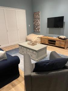 un soggiorno con divano e TV di 2-Bedroom apartment - Riverside bliss in Paarl a Paarl