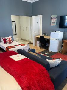 a bedroom with two beds and a desk and a room with at 2-Bedroom apartment - Riverside bliss in Paarl in Paarl