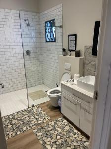 y baño con ducha, aseo y lavamanos. en 2-Bedroom apartment - Riverside bliss in Paarl, en Paarl