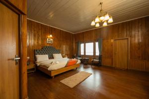 Arcadia Heritage Resort في دارجيلنغ: غرفة نوم بسرير في غرفة بجدران خشبية