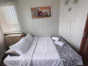 um quarto com uma cama branca num quarto em Apartament confortabil em Chişinău