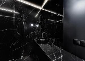 Baño negro con lavabo y espejo en Eclipse Black Room, en Bielsko-Biala