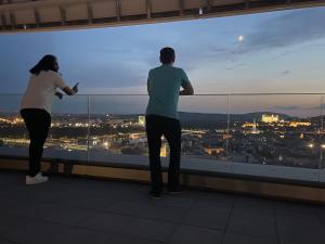 two people standing on top of a building looking at the city at SAG Sky Park Residence Free parking and Wi-Fi in Bratislava +23 photos