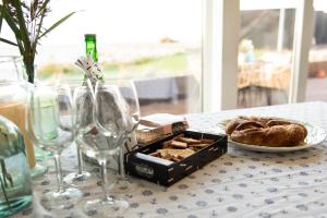 a table with a plate of bread and wine glasses at Merevaatega majutus Kärdla sadamas in Kärdla