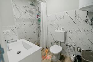uma casa de banho com um WC branco e um lavatório. em Apartman Wagner em Bugojno
