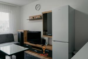 ein Wohnzimmer mit einem Kühlschrank und einem Tisch in der Unterkunft Apartman Wagner in Bugojno