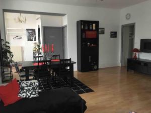 a living room with a table and a dining room at Appartement spacieux in Flize