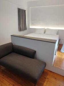 een kleine kamer met een bed en een bank bij PETMEZA TOP BY DIMITROPOULOS in Aigio