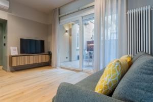 uma sala de estar com um sofá e uma televisão em Green Luxury Apartment by Wonderful Italy em Turim