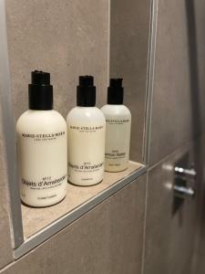 een groep van drie shampooflessen op een plank in een badkamer bij In het Assendorpje in Zwolle