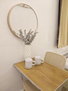 stół z dwoma kubkami i lustrem w obiekcie VG Pension & Residences w mieście Adlawon