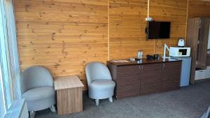 a room with two chairs and a desk and a television at Садиба Буланово in Bulanove +82 photos