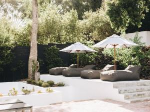 two pillows and umbrellas sitting on a patio at MooiBaai in Hout Bay