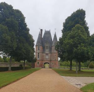 an old castle with trees in front of it at Wildberry cottage in Orgères-la-Roche