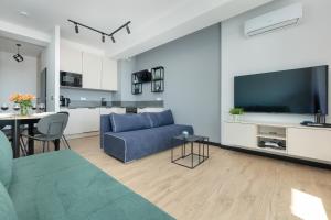 a living room with a blue couch and a kitchen at Top Water View Studio Porta Mare with AC by Renters in Dziwnówek