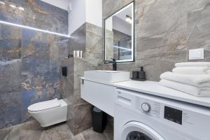 a bathroom with a sink and a washing machine at Top Water View Studio Porta Mare with AC by Renters in Dziwnówek