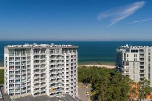 two tall white apartment buildings next to the ocean at Top Water View Studio Porta Mare with AC by Renters in Dziwnówek
