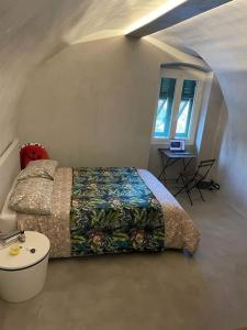Schlafzimmer mit einem Bett, einem Tisch und einem Fenster in der Unterkunft My little beach cabin in Ventimiglia