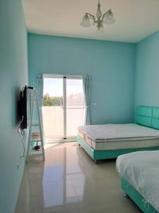 Un dormitorio con dos camas y una puerta corrediza de cristal. en Blue sky holidays B&B, en Taitung