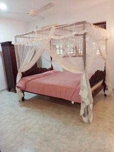 Mal villa في يوناواتونا: غرفة نوم بسرير مع مظلة