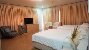 a hotel room with a bed and a television at Honey Suite Room Inside Bee Cafe Cebu at Ayala Area in Cebu City
