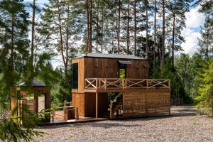 ein kleines Holzhaus mit Balkon im Wald in der Unterkunft Serenity Forest 1 