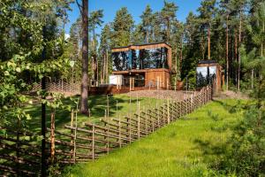 une maison dans les bois avec une clôture en bois dans l'établissement Serenity Forest 1, 