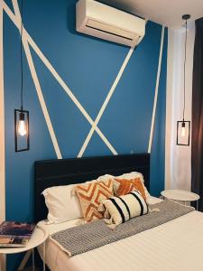 a bedroom with a blue wall and a bed with pillows at ITCC Manhattan Suites by Pleasant Amenities in Donggongon