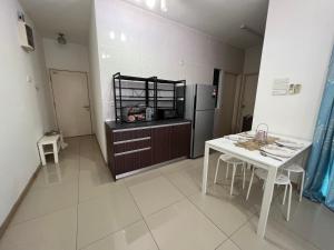 eine Küche mit einem weißen Tisch und einem Kühlschrank in der Unterkunft Vista Alam in Shah Alam