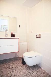 a bathroom with a white toilet and a sink at Space age Jaffa Apartment in Tel Aviv