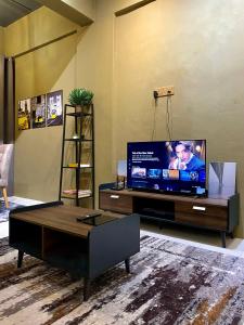a living room with a large flat screen tv at The Concrete Cave - Plaza Temerloh in Temerloh