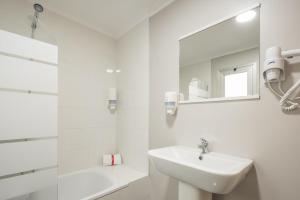 Baño blanco con lavabo y espejo en Macflats Ciudad de las Ciencias, en Valencia